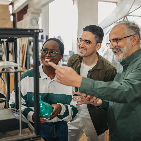 A professor talks to two students in the Collaboratorium